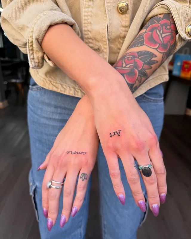Small fine-line tattoos on a hand and fingers